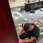 Operatore di Raia srl applica gli sticker in un negozio.