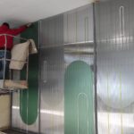 Operatore di Raia srl attacca pannelli a muro dalla piattaforma di una gru.
