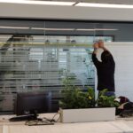 Operatore di Raia srl intento ad applicare vetrofanie in un ufficio.