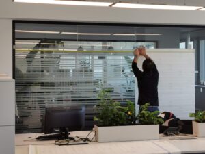 Operatore di Raia srl intento ad applicare vetrofanie in un ufficio.