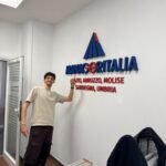 Operatore della Raia srl indica insegna sul muro.