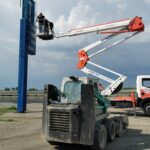 Operatori della Raia srl. montano insegna usando gru e caterpillar.