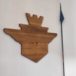Sagoma di legno appesa al muro con lancia.