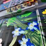 Dettaglio delle vetrofanie floreali sulla facciata di negozio Gucci.