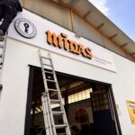 Operatore di Raia srl monta pannello con insegna di Midas.